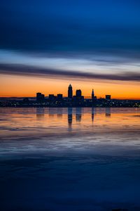 Preview wallpaper city, buildings, coast, sunset, dusk, reflection