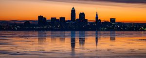 Preview wallpaper city, buildings, coast, sunset, dusk, reflection