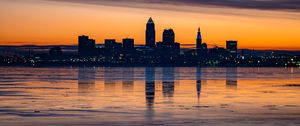 Preview wallpaper city, buildings, coast, sunset, dusk, reflection