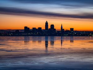 Preview wallpaper city, buildings, coast, sunset, dusk, reflection