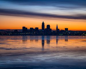 Preview wallpaper city, buildings, coast, sunset, dusk, reflection