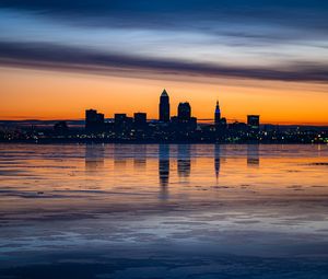 Preview wallpaper city, buildings, coast, sunset, dusk, reflection