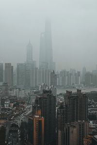 Preview wallpaper city, buildings, fog, aerial view