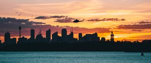 Preview wallpaper city, buildings, helicopter, coast, dusk, dark