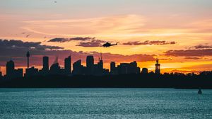 Preview wallpaper city, buildings, helicopter, coast, dusk, dark
