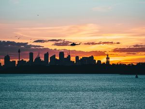 Preview wallpaper city, buildings, helicopter, coast, dusk, dark