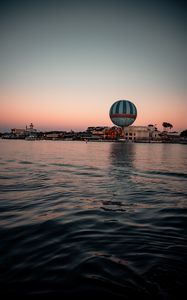 Preview wallpaper city, buildings, hot air balloon, water, waves, twilight