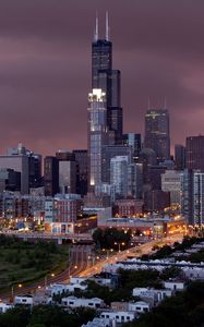 Preview wallpaper city, buildings, houses, roads, light, sky, storm, clouds, grass, trees