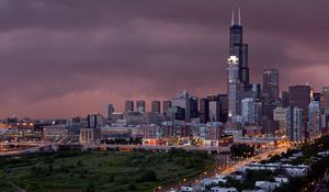 Preview wallpaper city, buildings, houses, roads, light, sky, storm, clouds, grass, trees