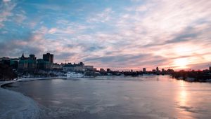 Preview wallpaper city, buildings, lake, ice, clouds, sunset