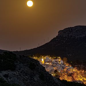 Preview wallpaper city, buildings, lights, mountains, moon, night