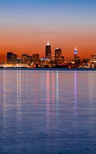 Preview wallpaper city, buildings, lights, water, reflection, sunset
