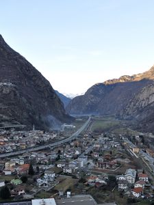 Preview wallpaper city, buildings, mountains, rocks, gorge, shadow