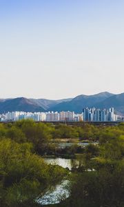 Preview wallpaper city, buildings, mountains, trees, river