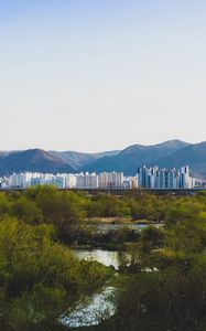 Preview wallpaper city, buildings, mountains, trees, river