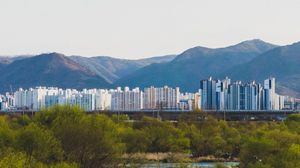 Preview wallpaper city, buildings, mountains, trees, river