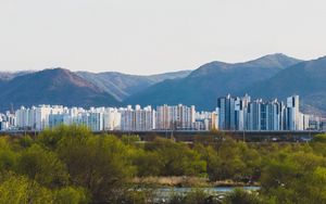 Preview wallpaper city, buildings, mountains, trees, river