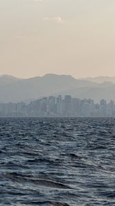 Preview wallpaper city, buildings, mountains, sea, waves, fog