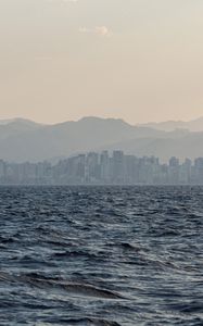 Preview wallpaper city, buildings, mountains, sea, waves, fog