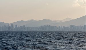 Preview wallpaper city, buildings, mountains, sea, waves, fog