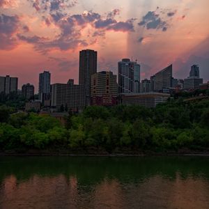 Preview wallpaper city, buildings, river, sunset, dusk