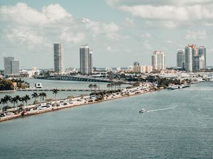 Preview wallpaper city, buildings, road, palm trees, boat, sea