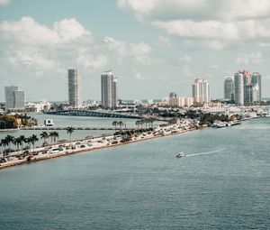 Preview wallpaper city, buildings, road, palm trees, boat, sea