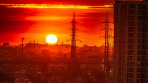 Preview wallpaper city, buildings, road, sun, sunset, dark