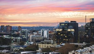 Preview wallpaper city, buildings, roofs, sunset