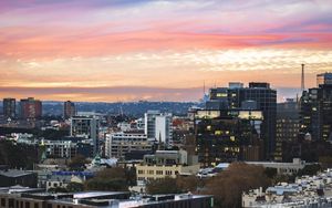 Preview wallpaper city, buildings, roofs, sunset