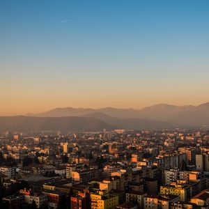 Preview wallpaper city, buildings, roofs, mountains, aerial view