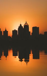 Preview wallpaper city, buildings, silhouettes, sunset, water, reflection, dark