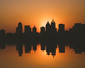 Preview wallpaper city, buildings, silhouettes, sunset, water, reflection, dark