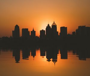 Preview wallpaper city, buildings, silhouettes, sunset, water, reflection, dark