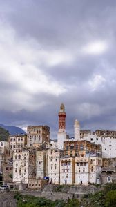 Preview wallpaper city, buildings, sky, hills, clouds