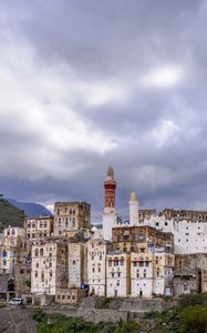 Preview wallpaper city, buildings, sky, hills, clouds
