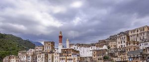 Preview wallpaper city, buildings, sky, hills, clouds