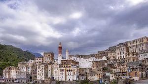 Preview wallpaper city, buildings, sky, hills, clouds