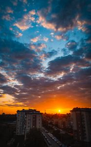 Preview wallpaper city, buildings, sunset, clouds, parking