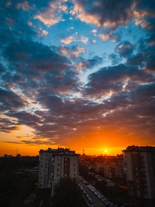 Preview wallpaper city, buildings, sunset, clouds, parking