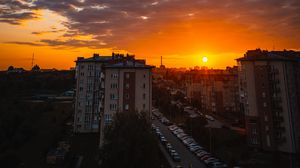 Preview wallpaper city, buildings, sunset, clouds, parking