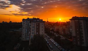 Preview wallpaper city, buildings, sunset, clouds, parking