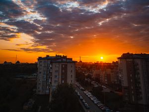 Preview wallpaper city, buildings, sunset, clouds, parking