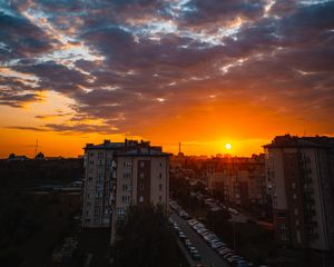 Preview wallpaper city, buildings, sunset, clouds, parking