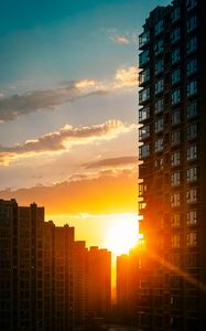 Preview wallpaper city, buildings, sunset, rays