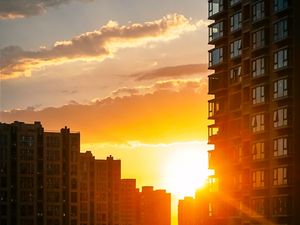 Preview wallpaper city, buildings, sunset, rays