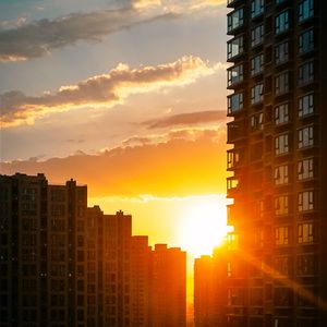 Preview wallpaper city, buildings, sunset, rays
