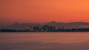 Preview wallpaper city, buildings, sunset, sea, horizon