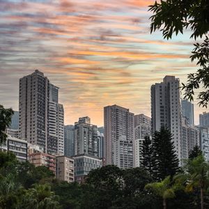 Preview wallpaper city, buildings, trees, sunset