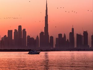 Preview wallpaper city, buildings, water, boat, birds, sunset